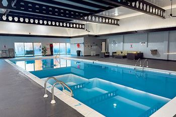 A large indoor swimming pool with a diving board.